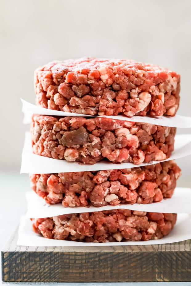 Straight on photo of a stack of hamburger patties made from homemade ground burger meat.