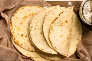 Overhead photo of a stack of flour tortillas made from scratch.