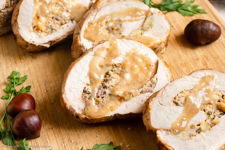 Photo of thick slices of turkey roulade with stuffing and gravy.
