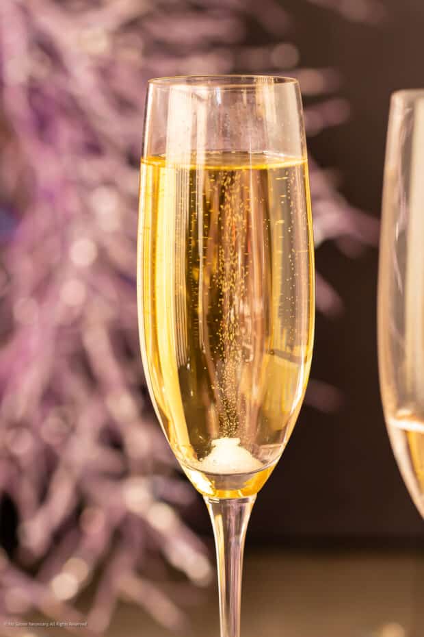 Close up photo of a cocktail with champagne in a flute glass.