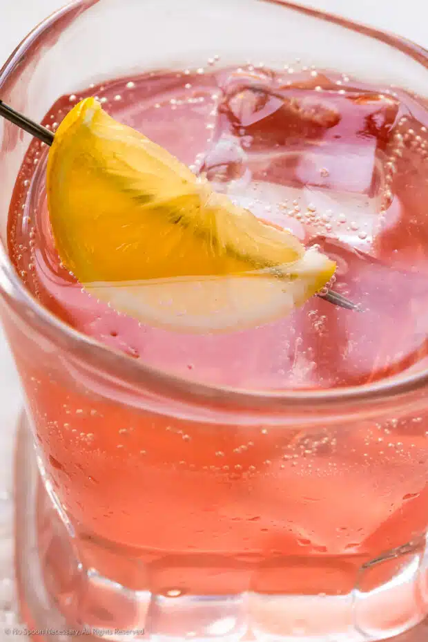 Close-up photo of a pink cocktail with vodka and lemon.