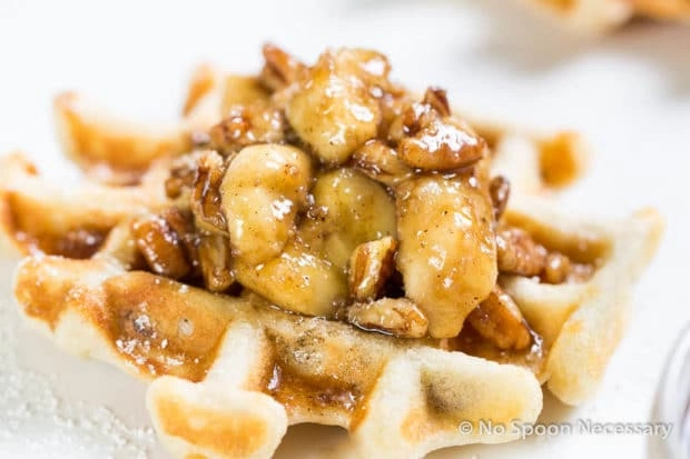closeup of buttermilk waffles topped with bananas and pecans