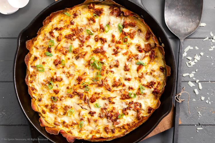 Overhead photo of a fully baked frittata with potato in a cast iron skillet