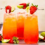 Photo of three alcoholic drinks with strawberries in tall glasses.