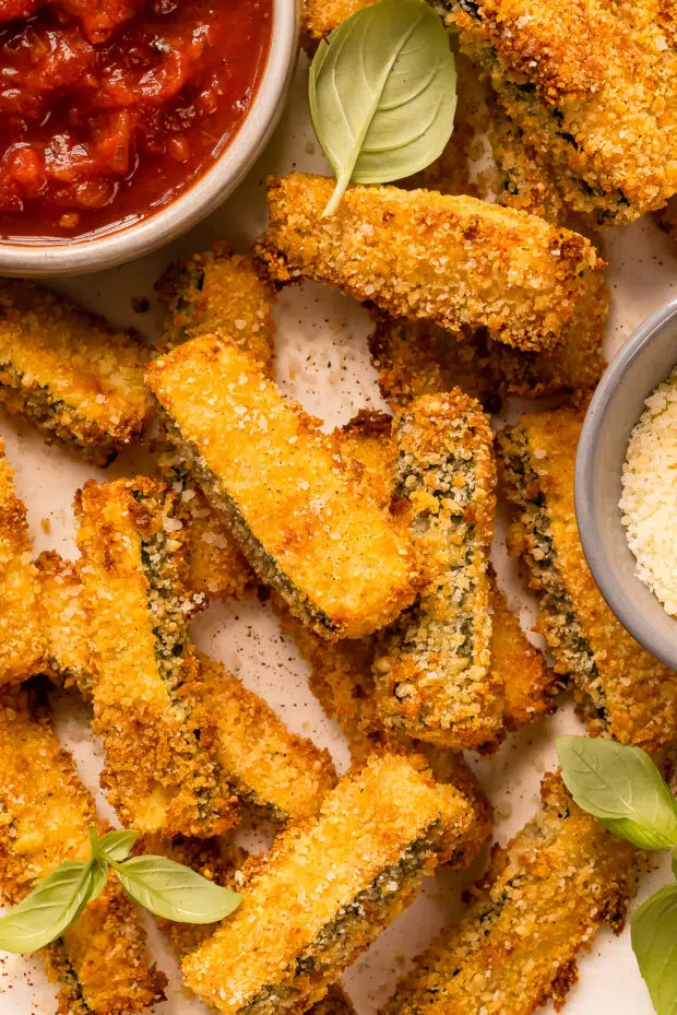 Overhead, close-up photo of baked zucchini sticks.