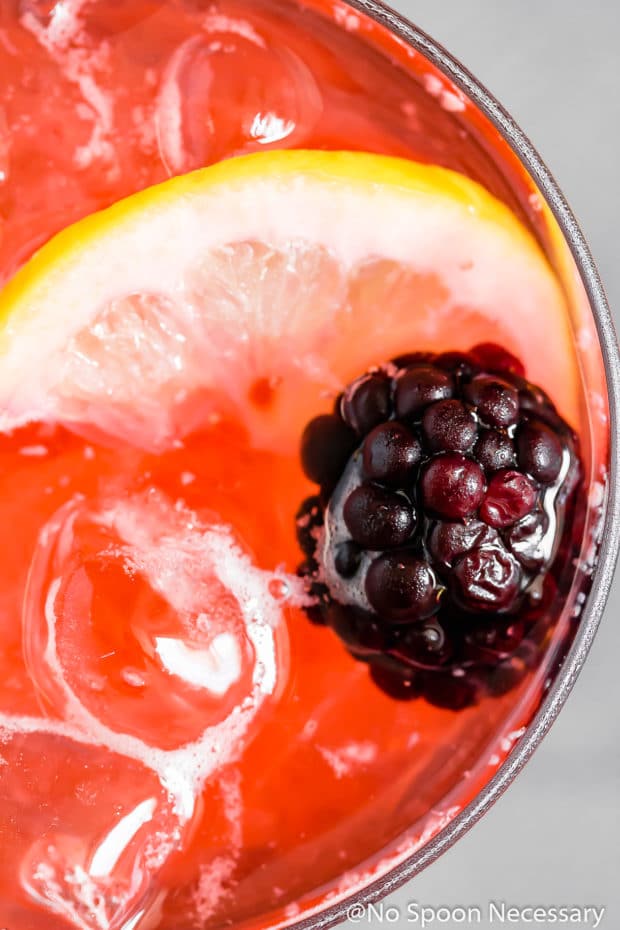 overhead of blackberry cocktail with blackberry and lemon garnish