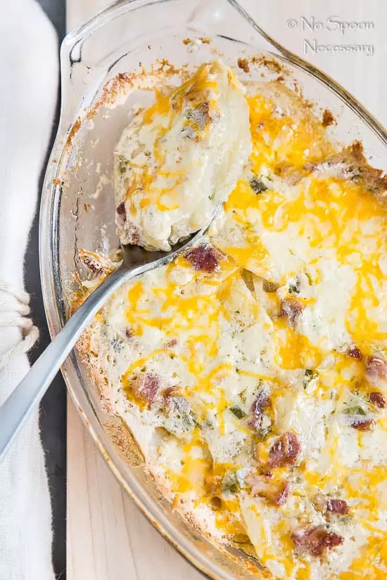 using a spoon to scoop up potatoes au gratin recipe