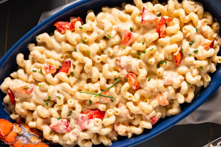 Overhead photo of lobster with macaroni and cheese in a large serving platter.