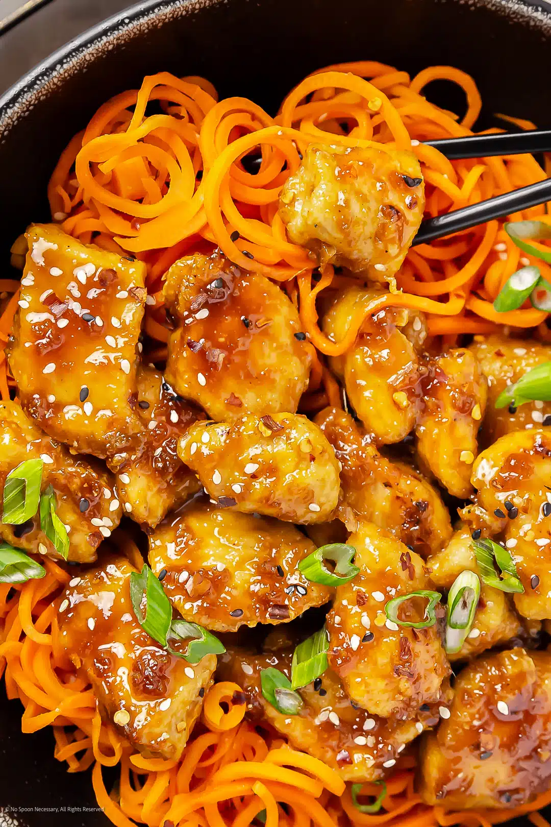 Close-up photo of garlic honey chicken stir fried with carrots.