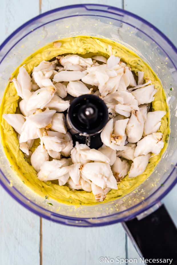 Overhead shot of a food processor bowl filled with the second step of ingredients to make Crab Cake Deviled Egg filling.