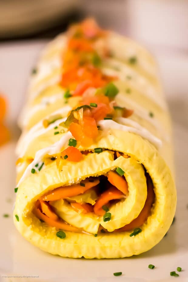 Straight on photo of a rolled omelette.