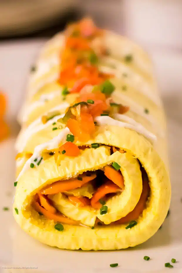 Straight on photo of a rolled omelette.