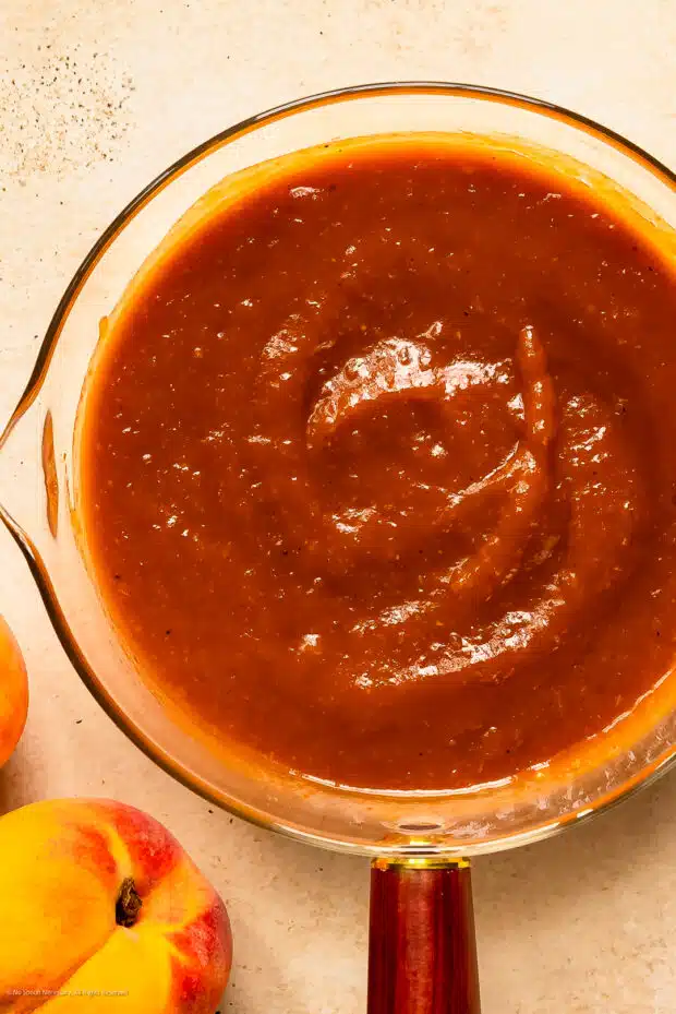 Overhead photo of peach barbecue sauce in a saucepan.