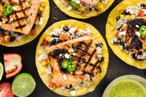 Overhead photo of a salmon tostada with black beans and rice.