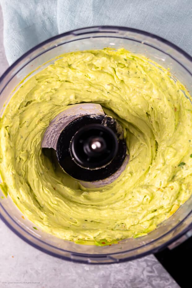 Overhead photo of homemade avocado butter in the bowl of a food processor.