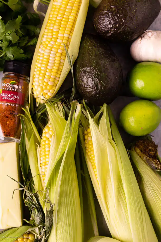 Overhead photo of the ingredients to make avocado butter and corn on the cob.