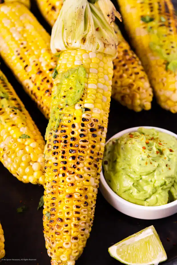 Close-up photo of a grilled corn on the cob slathered with homemade butter made from avocados.