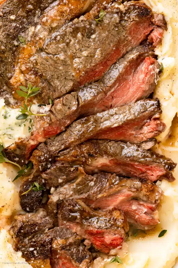 Close-up photo of the juicy texture of a slow cooked steak in the oven.