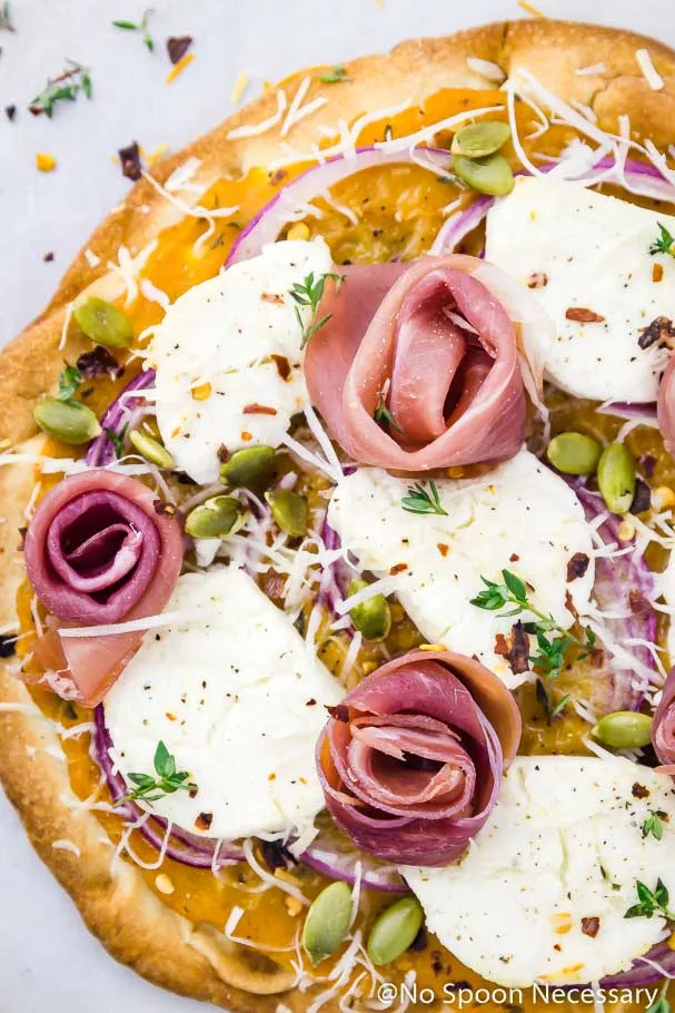 Overhead, up-close shot of the prosciutto roses on a Butternut Squash Flatbread Pizza with Goat Cheese & Pumpkin Seeds