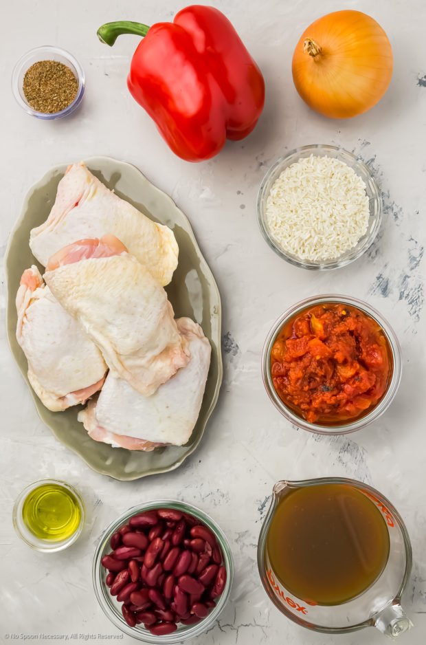 Overhead image of all the ingredients in cajun chicken rice recipe neatly arranged individually on a counter.