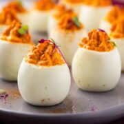 Straight on photo of ten fancy deviled eggs with sweet red peppers.