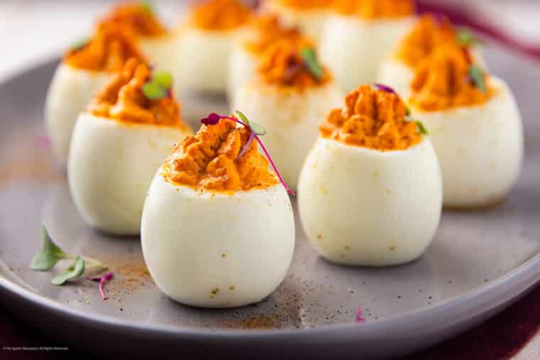 Straight on photo of ten fancy deviled eggs with sweet red peppers.