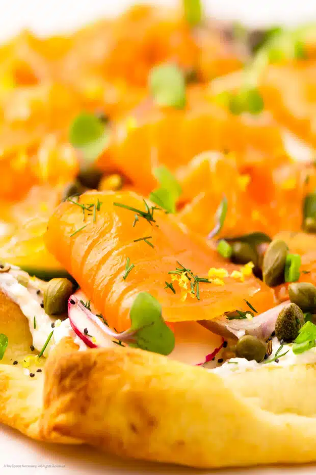 Close-up photo of a thin slice of salmon on pizza.