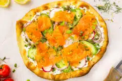 Overhead photo of smoked salmon pizza with cream cheese.