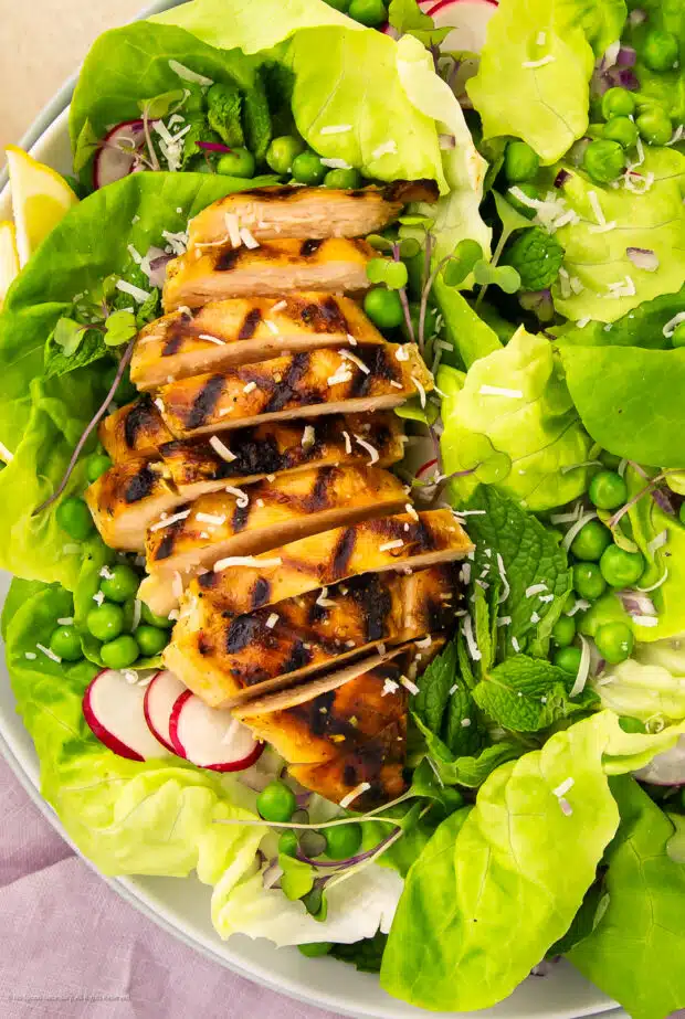 Overhead photo of a fresh pea salad with grilled chicken and fresh veggies.
