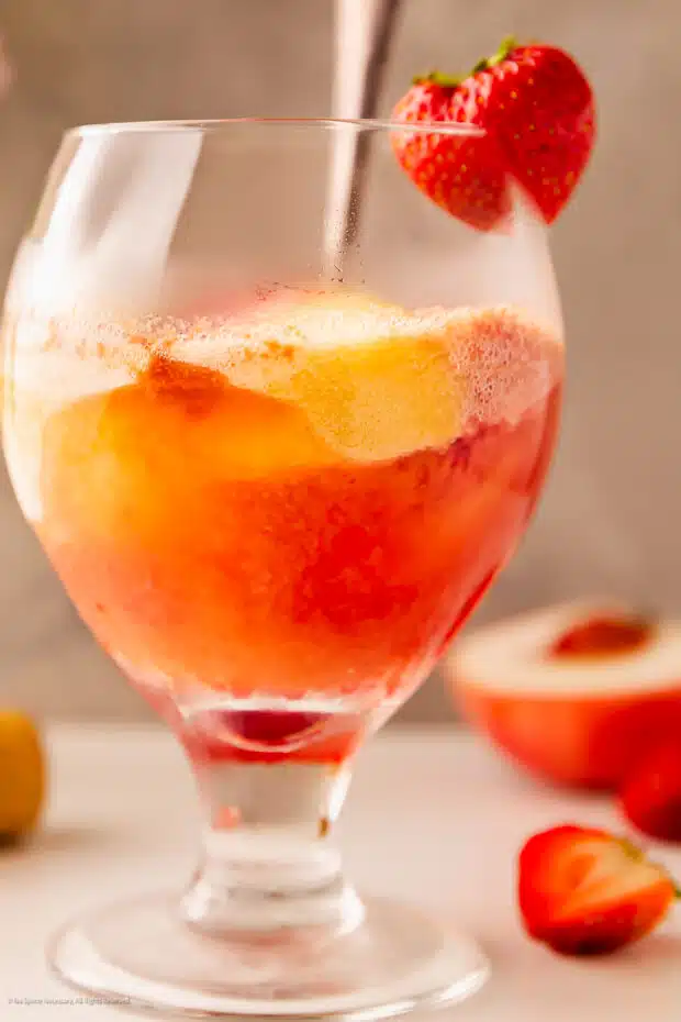 Straight on photo of a rosè sorbet cocktail garnished with a fresh strawberry.