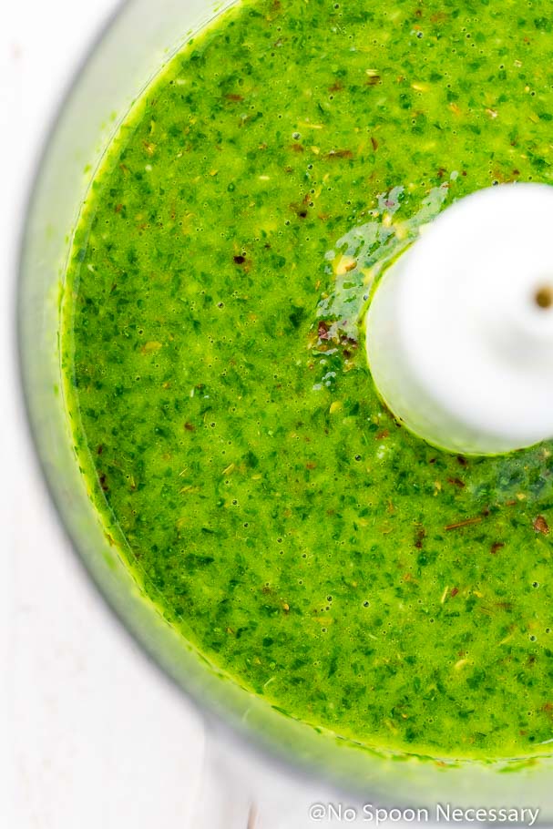 Overhead, up-close shot of chimichurri sauce in a food processor bowl. (Photo of the second part of step 1 in the recipe for Chimichurri Grilled Shrimp & Corn Salad)