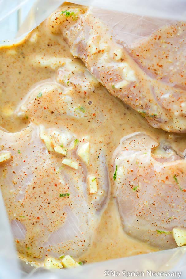 Overhead shot into a clear zip-closure bag of chicken thighs in a southwest buttermilk marinade