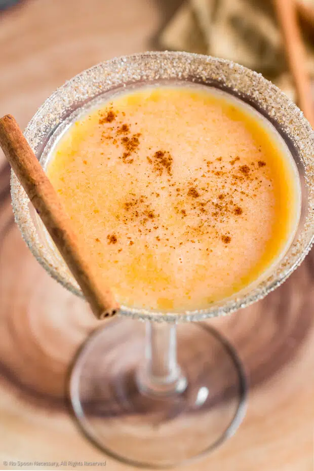 Angled photo of a pumpkin cocktail garnished with pumpkin pie spice in a martini glass.
