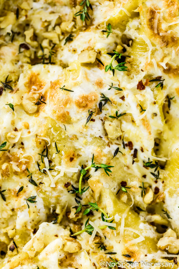 Overhead, up-close shot of Baked Pumpkin Stuffed Shells topped with fresh thyme and crushed walnuts.