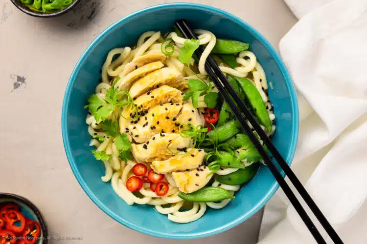 Overhead photo of chicken udon noodles with miso broth and snap peas in a soup bowl.