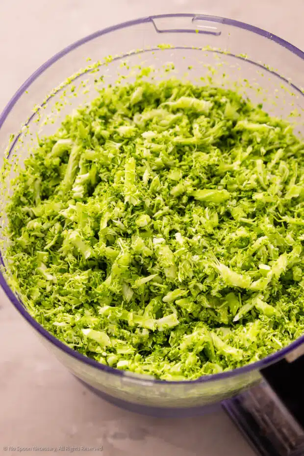 Close-up photo of broccoli rice in a food processor bowl.