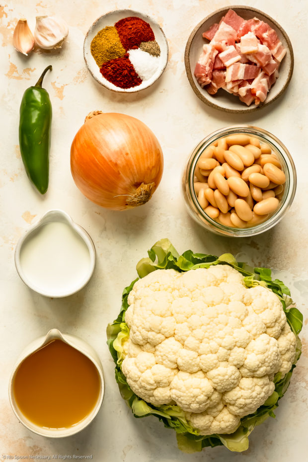 Overhead photo of all the ingredients needed to make healthy cauliflower soup neatly arranged in individual bowls.