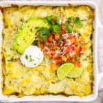 Overhead photo of enchilada casserole with chicken in square white baking dish.