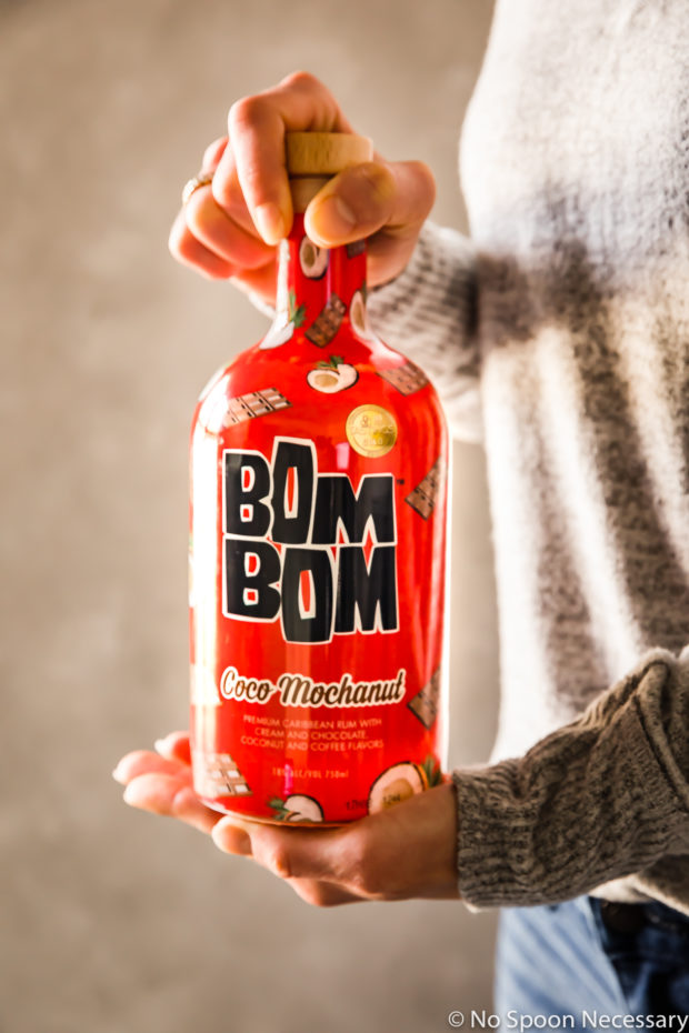 Straight on shot of a person holding a bottle of Bom Bom Coco Mochanut.