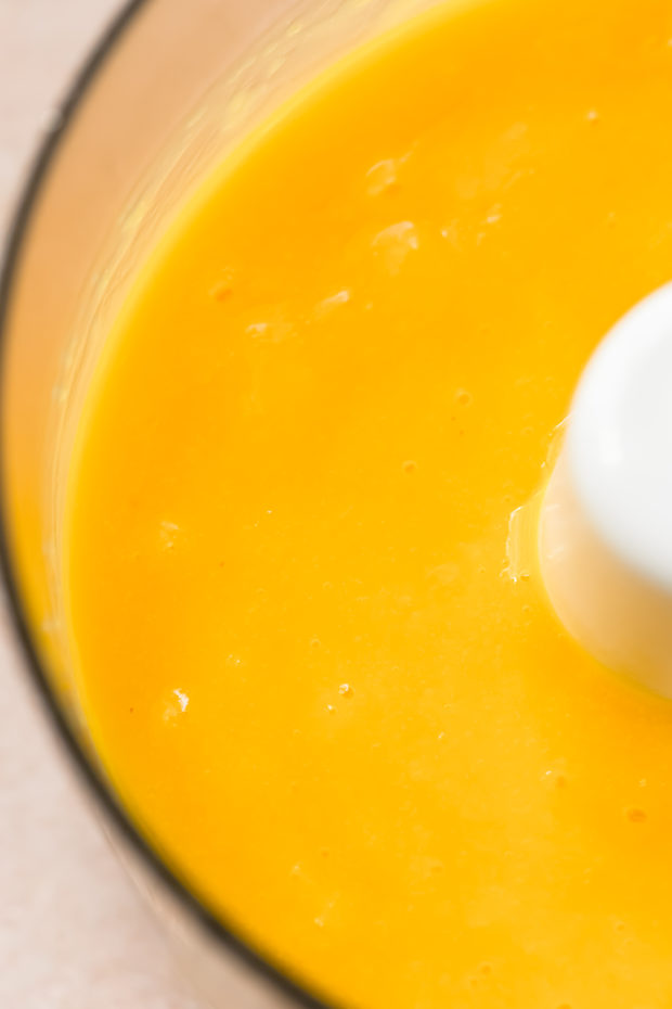 Overhead, up close shot of mango poke dressing in a food processor bowl.