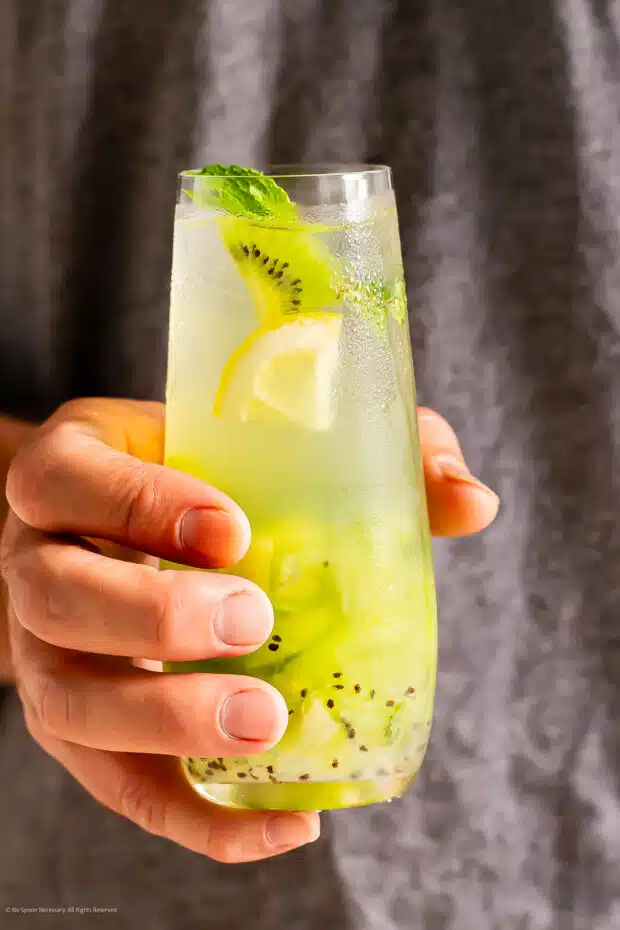 Straight on photo of a person's hand holding a fruity tequila drink.