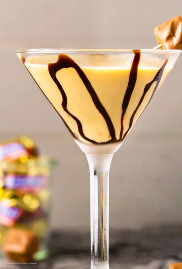 Straight on photo of a chocolate martini in a martini glass decorated with chocolate sauce.