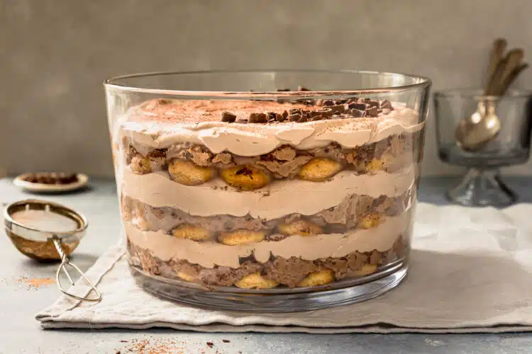 Straight on photo of tiramisu chocolate layered in a trifle bowl.