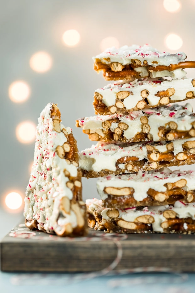 Straight on photo of pieces of Chocolate Peppermint Bark stacked on top of each other on a gray wood board with one piece off to the side.