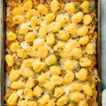 Overhead photo of baked gnocchi with caramelized onions and cheese on a baking sheet.