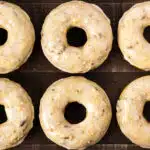 Overhead photo of six maple donuts with maple glaze on a wood serving tray.