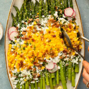 Action photo of hands serving up salad with asparagus and egg