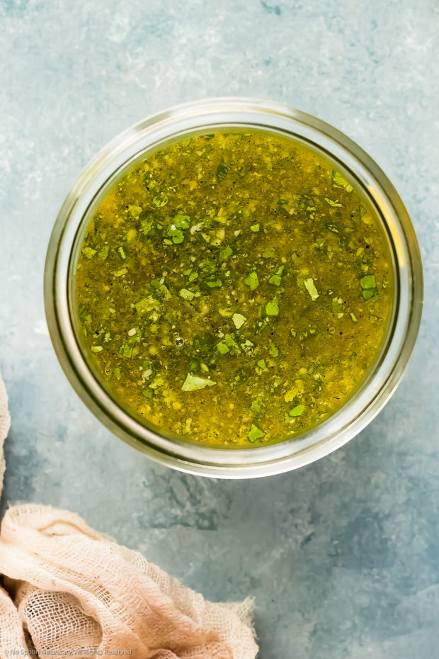 Overhead photo of basil vinaigrette dressing for no-mayonnaise pasta salad in a glass jar.