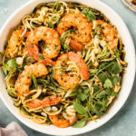 Overhead photo of Zucchini Vegetable Noodle Stir Fry with shrimp in a white serving bowl.