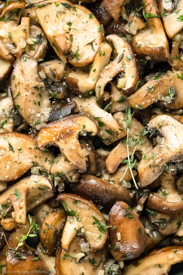 Overhead up close photo of perfectly sauteed mushrooms seasoned with salt, pepper and thyme.